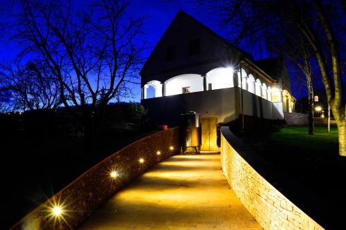 a house lit up at night with lights on a sidewalk at Figula Vendégház in Balatonfüred