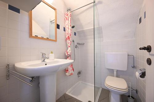 a bathroom with a sink and a toilet and a shower at Sole e Fiori di Erik Gaebler in Paschero