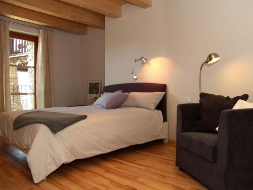 a bedroom with a large bed and a chair at Sole e Fiori di Erik Gaebler in Paschero