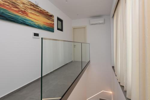 a glass staircase in a room with a painting on the wall at Artemis Villa in Lithakia