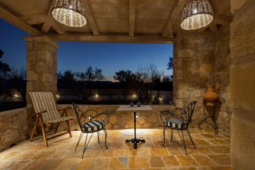 a patio with chairs and a table and lights at Le tresor de Marie - Charming Traditional Retreat, by ZanteWize in Gaïtánion