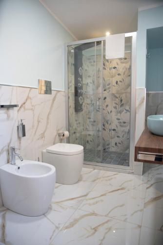 a bathroom with a shower and a toilet and a sink at La Dolce Vita rooms & suite in Agrigento