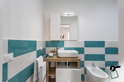 a bathroom with blue and white tiled walls and a sink at HOTIDAY Room Collection - Byò Home in Sorrento