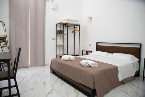 a bedroom with a bed with two towels on it at La Dolce Vita rooms & suite in Agrigento