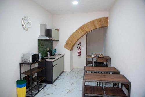 a kitchen with two wooden tables and a stove at La Dolce Vita rooms & suite in Agrigento