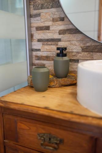 a bathroom counter with a bottle of soap on it at Magnolias Cottage in Lousã