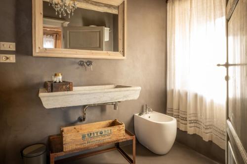 a bathroom with a sink and a toilet and a mirror at L'imbrunire in Campiglia dʼOrcia