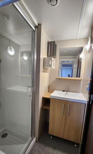 une salle de bain avec un lavabo et une douche dans l'établissement Mobile home 3 bedrooms, à Saint-Jean-de-Monts