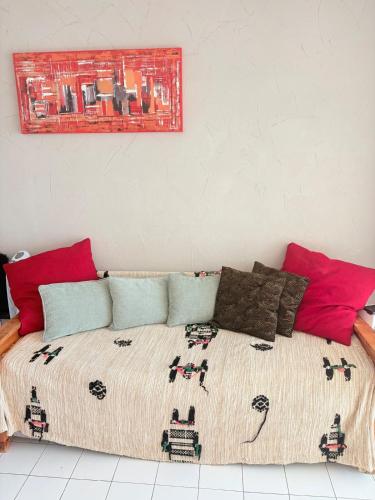 une chambre avec un grand lit avec des oreillers colorés dans l'établissement Les Sables Fins, Joli Appartement Front de Mer, 1 min des plages, Parking, à Sète