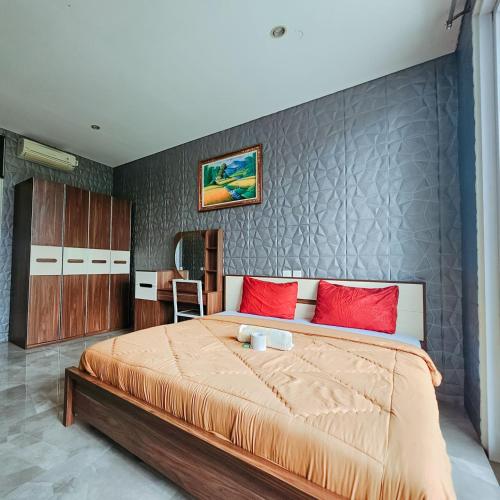 a bedroom with a large bed with red pillows at Margarita Surf Hostel Canggu in Canggu