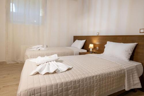 two beds in a hotel room with towels on them at Elevi in Tiros