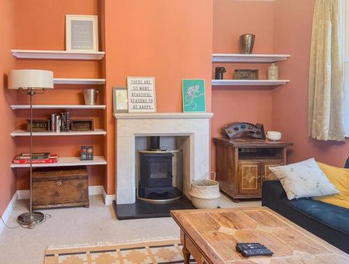 a living room with a fireplace and a couch at Charming Kenton Cottage in Kenton