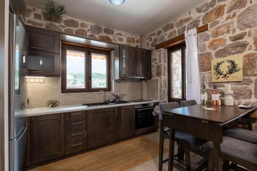 a kitchen with wooden cabinets and a table at Elevi in Tiros