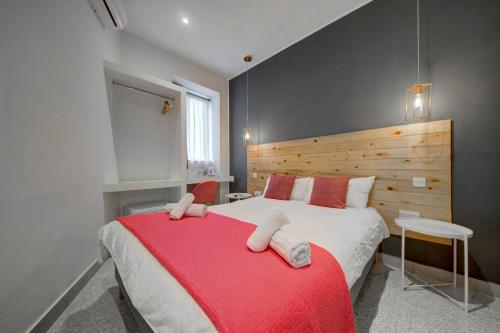 a bedroom with a large bed with a red blanket at CARO Boutique Guest House in San Ġwann