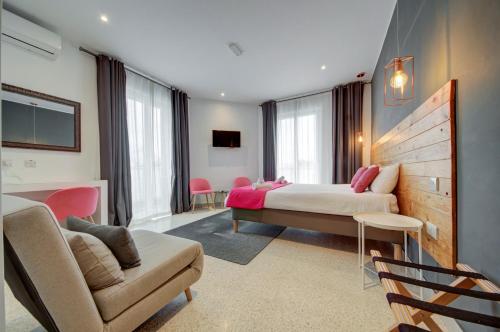 a hotel room with a bed and a couch at CARO Boutique Guest House in San Ġwann