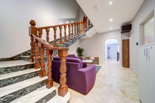 a living room with a purple couch and stairs at CARO Boutique Guest House in San Ġwann