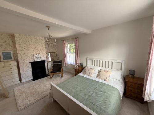 a bedroom with a bed and a fireplace at Charming Kenton Cottage in Kenton