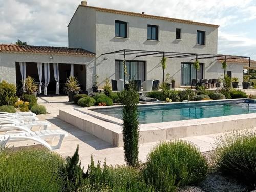 une maison avec une piscine devant une maison dans l'établissement villa 4 étoiles avec piscine et pool house, à Arles
