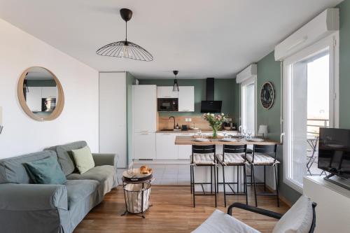 un salon avec un canapé et une cuisine dans l'établissement Golden Horizon - proche Intra-Muros, à Saint-Malo