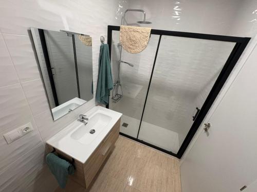 a white bathroom with a shower and a sink at apartamento san urbano in Almería