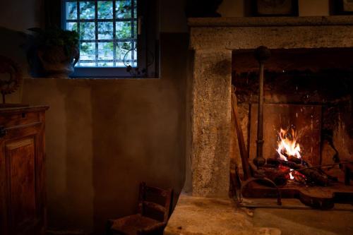 a fireplace with a fire in it in a room at L'imbrunire in Campiglia dʼOrcia