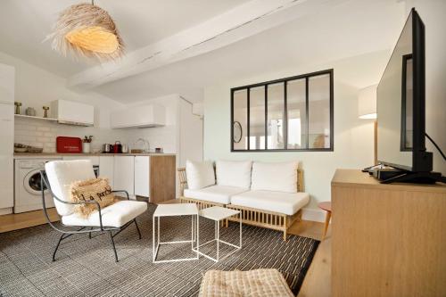 d'un salon avec un mobilier blanc et une télévision. dans l'établissement Magnificent apartment - AC- 2BR- Saint-Tropez, à Saint-Tropez
