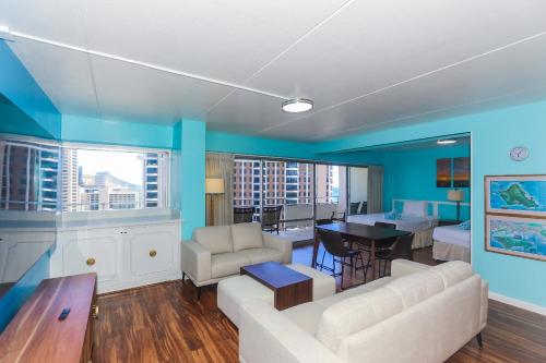 ホノルルにあるIlikai Tower 1934 Condo with Fully Equipped Kitchen - Great for longer stays!の青い壁のリビングルーム(ソファ、テーブル付)