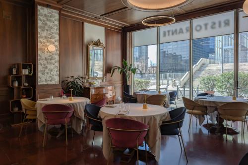 a restaurant with tables and chairs and large windows at Hotel Dei Congressi in Rome