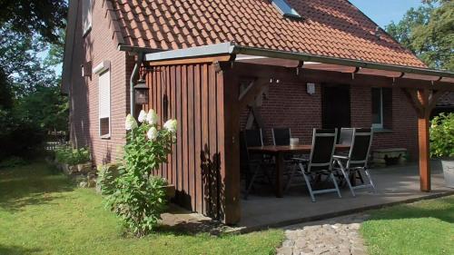 a pavilion with a table and chairs in a backyard at Ferienhaus Mit Überdachter Terrasse Und Carport in Walsrode