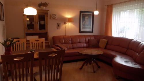 a living room with a couch and a table at Ferienhaus Mit Überdachter Terrasse Und Carport in Walsrode