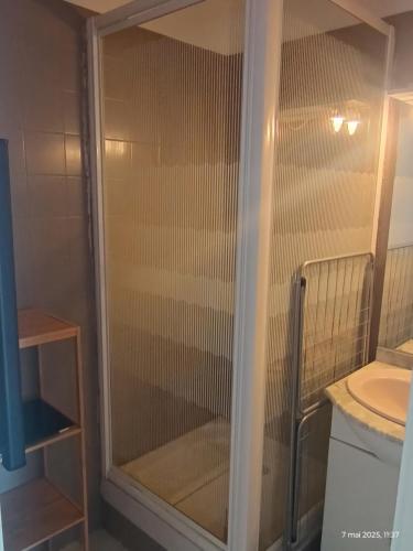 une douche avec une porte vitrée dans une salle de bain dans l'établissement Studio à Valras, à Valras-Plage