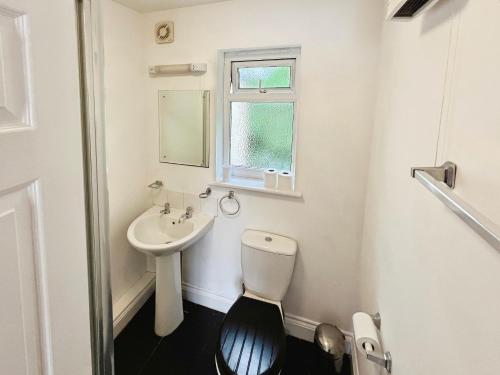 Thistle Cottage في Wootton Bridge: حمام أبيض مع مرحاض ومغسلة