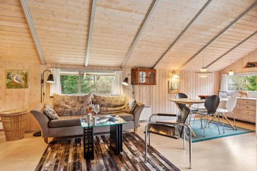 a living room with a couch and a table at Charming And Cozy House Close To Ebeltoft in Ebeltoft