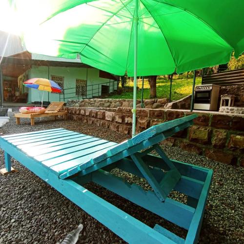 a blue picnic table with a green umbrella at Hostel 555 by VL in Alaverdi