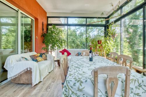 une salle à manger avec une table, des chaises et des fenêtres dans l'établissement Appartement La Montagne Sud, à Allemans