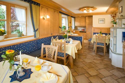 a restaurant with tables and chairs in a room at Pension Breitenlohner in Reit im Winkl