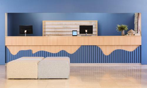 a reception desk in a blue room with a couch at Laguna Maradiso Hotel by Aminess in Novigrad Istria