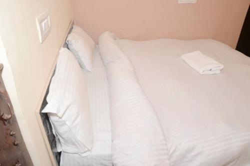a white bed with white sheets and pillows at SPOT ON Hotel Abhinandan in Meerut