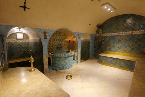 a large bathroom with blue tiled walls and a tub at Riad Cherifa in Chefchaouene