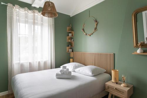 カンカルにあるRêve Emeraude - 100m de la Plageの白いシーツと窓のあるベッドのある寝室