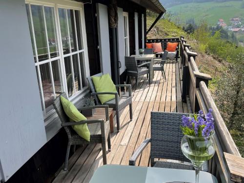 a wooden deck with chairs and tables on a house at Ferienhaus Lena in Seebach