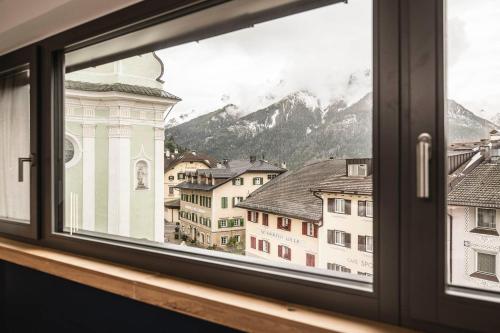 a window with a view of a city at The Post Mountain Residence in Dobbiaco