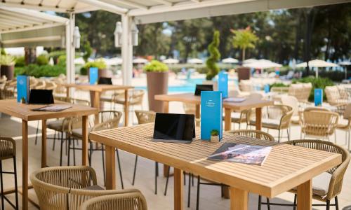 a group of tables and chairs in a restaurant at Laguna Maradiso Hotel by Aminess in Novigrad Istria
