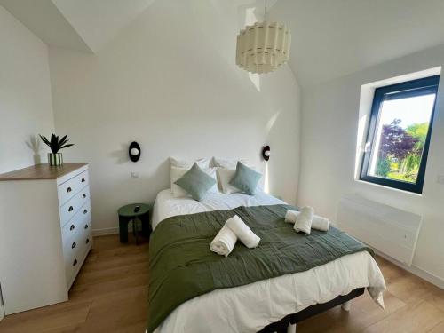 a bedroom with a large bed with two pillows at Appartement le Vintage, à deux pas du Port in Le Tréport