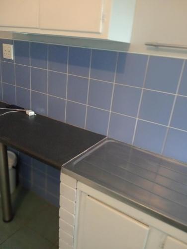 a kitchen with blue tiled walls and a counter at Moonlight Guesthouse - Boksburg in Boksburg