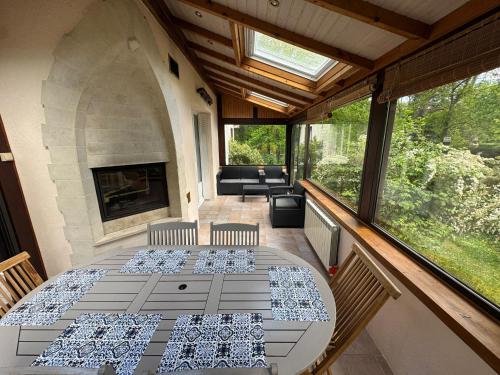 un patio avec une table, des chaises et une cheminée dans l'établissement Gîte La Rochetine, à Noisy-sur-École
