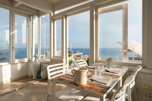 a dining room with a table and views of the ocean at Santo Stefano Home & Breakfast in Polignano a Mare
