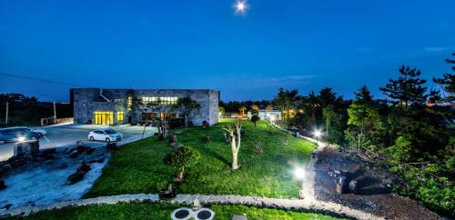 a view of a park at night with a building at Bada Maru Pension in Seogwipo