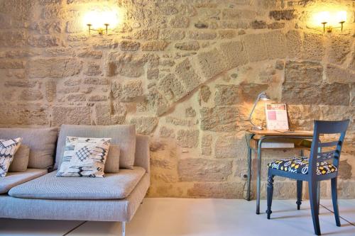 a room with a couch and a table and a desk at La suite du Duché in Uzès