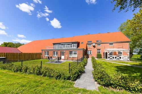 una gran casa de ladrillo con techo naranja en Ferienwohnung Sternstunde, en Bensersiel